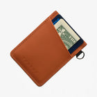Brown leather wallet with a dollar bill sticking out on a white background