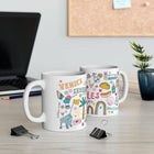 Two mugs with colorful designs on a desk with office supplies and a plant.