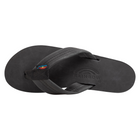 A single black rubber flip-flop sandal shown from a top-down view on a plain white background. The brand name 'RAINBOW' is embossed on the footbed, and a small colorful brand tag is attached to the strap.