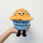 Plush toy resembling a blue muffin with text 'Muffin is Impossible' held by a hand against a light gray background
