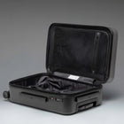 Black open suitcase on a gray background
