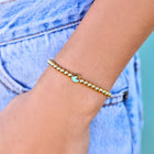 Model wearing Pura Vida Enamel Wave Gold Bead Stretch Bracelet