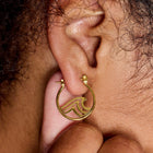 Model wearing Pura Vida Surfrider Gold Wave Hoop Earrings