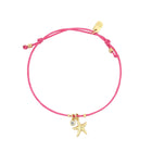 Pink bracelet with gold starfish charm on a white background