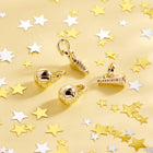 Gold charms on a yellow background with star confetti