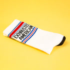 White sock with red, blue, and black text on a yellow background