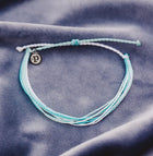 Pura Vida Coastal Way Bracelet on a violet background