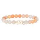 A beaded stretch bracelet featuring smooth peach, orange, and milky white translucent beads, with a small white tiger charm outlined in orange, displayed on a black background.