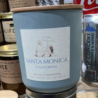 Blue candle labeled 'Santa Monica, California' with a Coca-Cola can in the background.