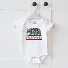 White baby onesie with California bear design on a hanger against a white background
