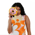 Woman holding a plush donut toy with a white background