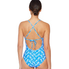 Woman wearing a blue floral swimsuit with criss-cross straps on a white background
