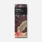 Packaged towel with tropical leaf design and 'nomadix' branding on a white background