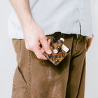 Person holding a leopard print wallet with a white background