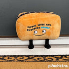 Plush toaster with face and text 'Sippin' Wine and Shopping Prime' on a doormat.
