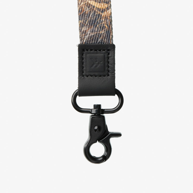 Close-up of a camouflage strap with a black clasp on a white background