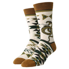 A pair of crew socks with a Southwestern geometric pattern in olive green, dark green, and brown on a cream speckled background. The socks feature a large snake graphic on the front leg and a brown ribbed cuff, toe, and heel.