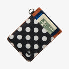 Polka dot wallet with money sticking out on a white background