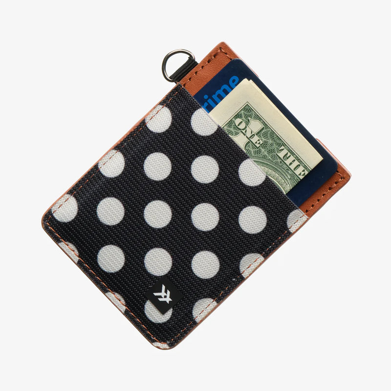 Polka dot wallet with money sticking out on a white background