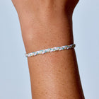 Bracelet on a wrist against a light blue background