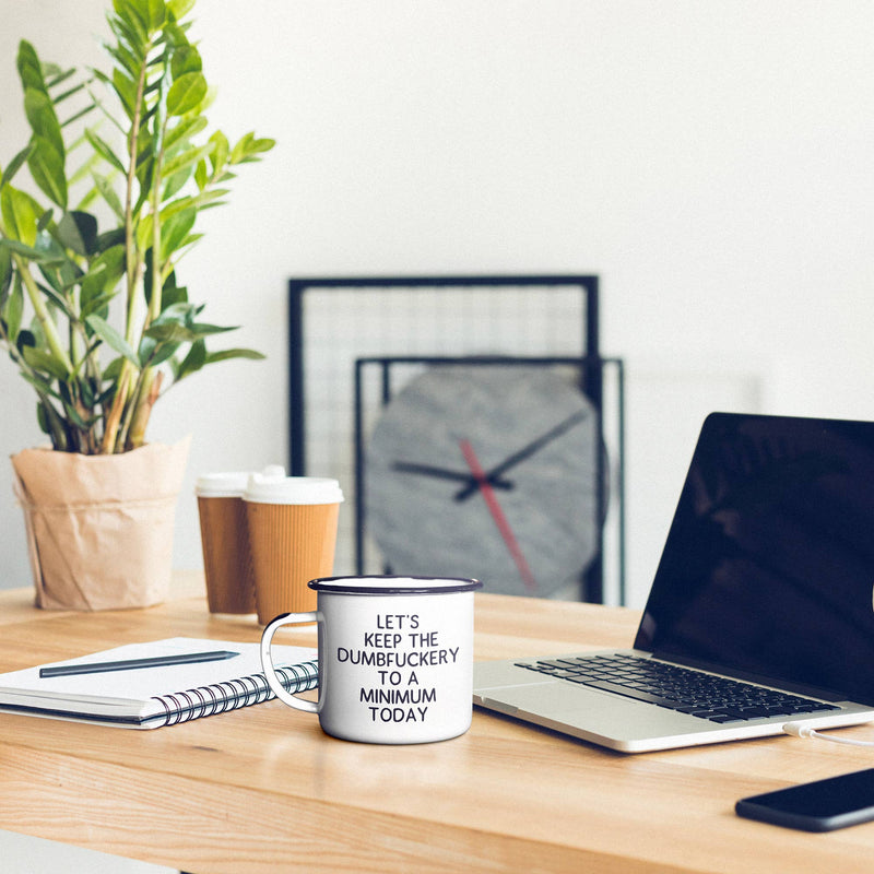 Desk setup with laptop, mug, and plant in a home office setting