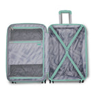 An open Samsonite spinner suitcase with a telescoping handle extended, showing the interior layout. The suitcase has a gray and white wavy geometric pattern with mint green trim, mesh pockets, and an X-stretching strap inside.