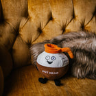 Plush toy resembling a pot with a face on a brown couch