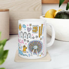 White mug with colorful illustrations on a white surface