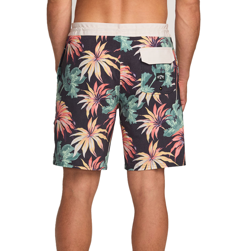 Tropical floral patterned shorts on a plain background back view