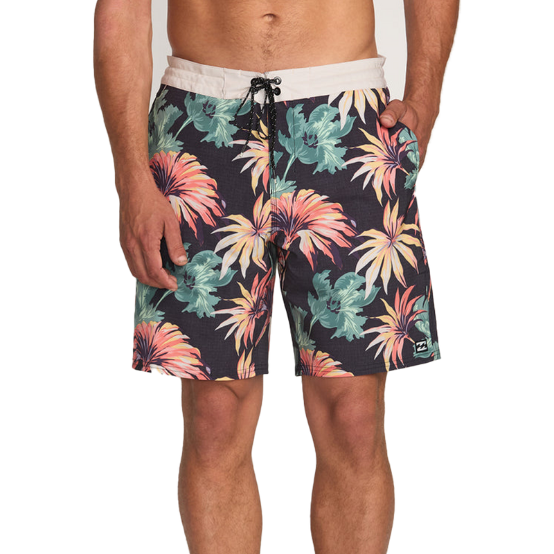Tropical floral patterned shorts worn by a person on a white background
