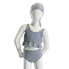Mannequin wearing a black and white checkered swimsuit with matching cap on a white background