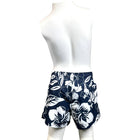 Mannequin wearing navy shorts with white floral pattern on a white background