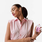 Woman holding a pink bottle with a white background