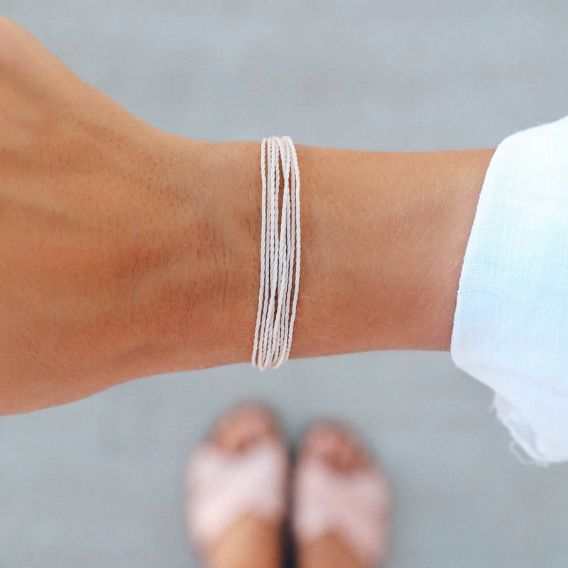 Model wearing white pura vida bracelet