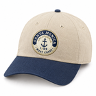 A structured baseball cap in beige and navy blue, featuring a circular embroidered patch on the front with an anchor and the text 'Santa Monica California 1909 West Coast'.