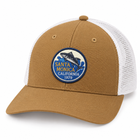 A tan and white trucker hat with a circular embroidered patch on the front featuring a fish and the text 'Santa Monica California 1979'.