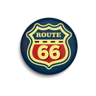 A circular pinback button featuring the classic Route 66 shield logo. The design has a dark navy blue background, a yellow border and text, and a red center with the number '66' in yellow.