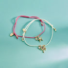 Two bracelets with charms on a teal background