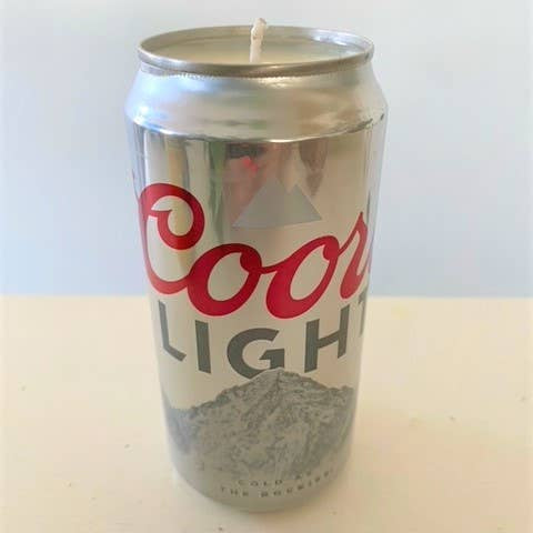 Coors Light beer can with a candle inside on a white background