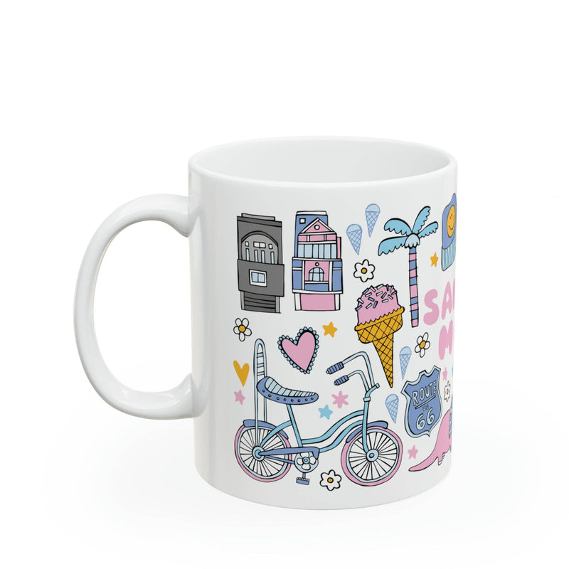 White mug with colorful illustrations including a bicycle, ice cream cone, and houses on a white background