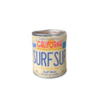 Can of California Surf Sup surf wax on a wooden surface with a blurred background