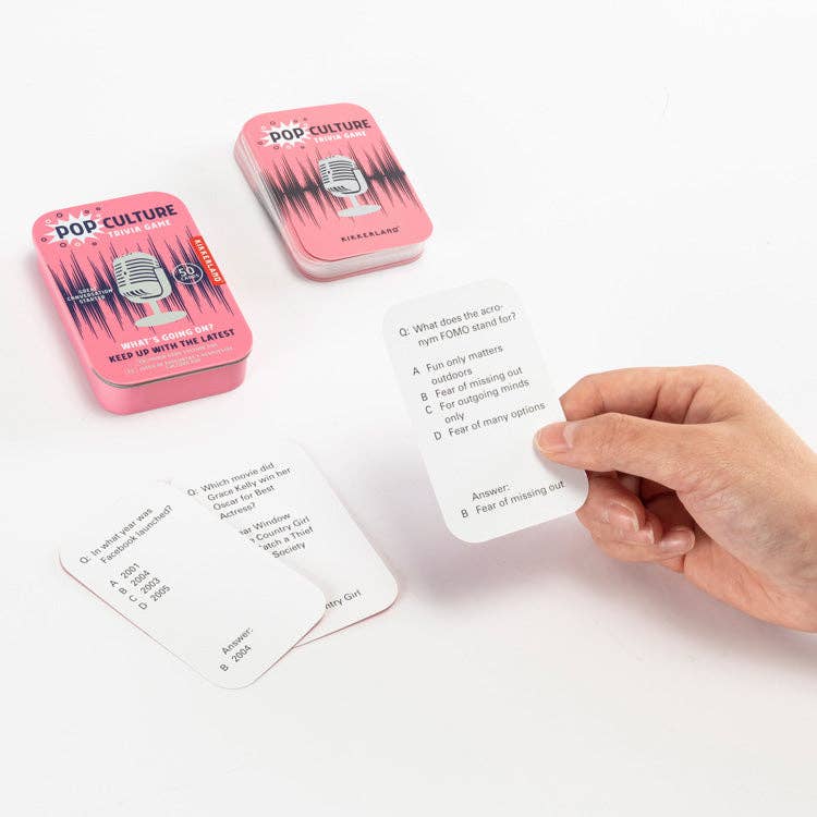 Pop culture trivia cards with pink tins on a white background