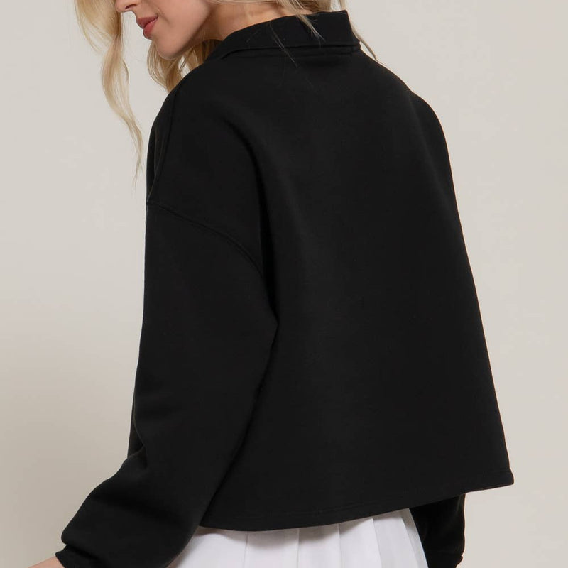 Woman wearing a black jacket and white skirt against a plain background