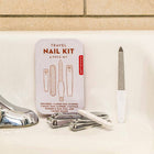 Travel nail kit with tools on a bathroom counter