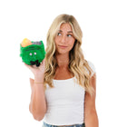 Woman holding a green toy with a face on a white background
