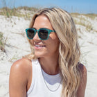 Woman wearing sunglasses on a sandy beach