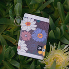 Floral-patterned keychain on green foliage