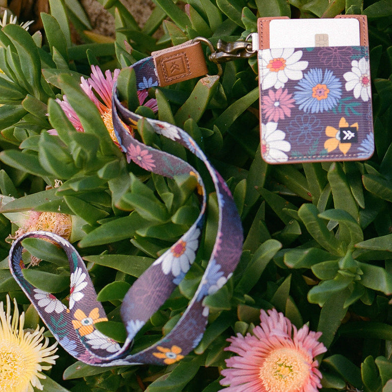 Floral lanyard and cardholder on green foliage with flowers