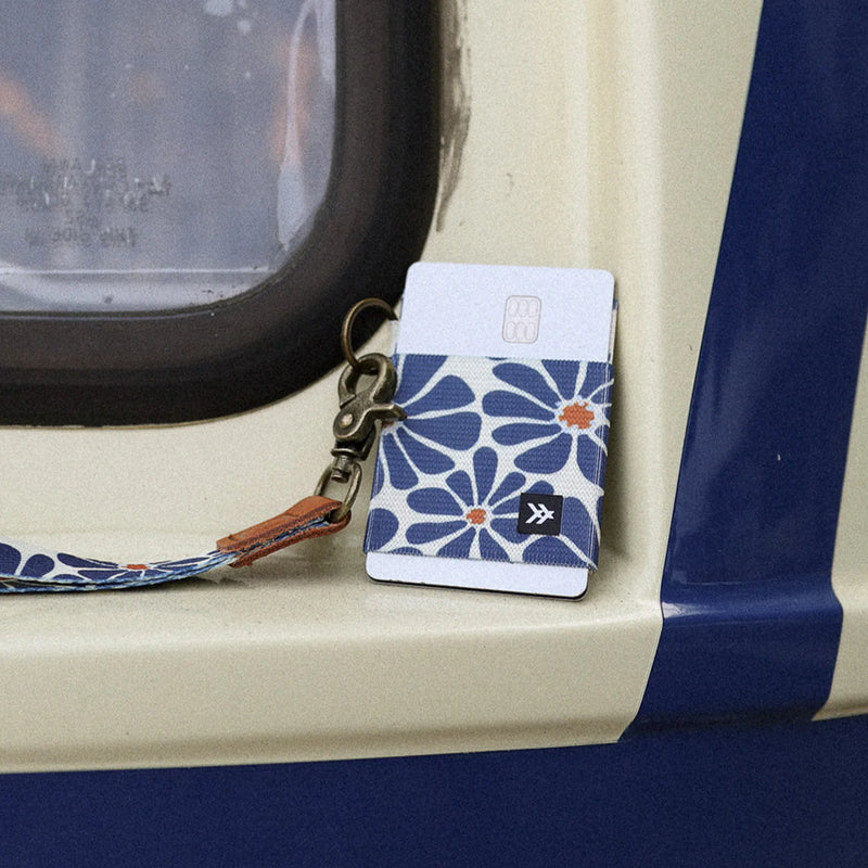 Floral patterned cardholder with strap on a vehicle's edge