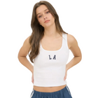 Woman wearing a white tank top with 'LA' lettering on a plain background
